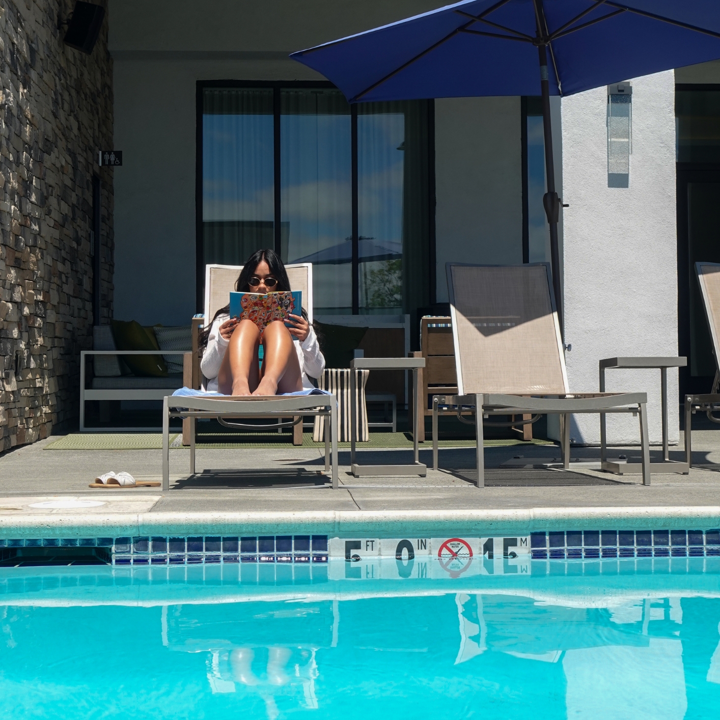 A guest relaxing on a pool lounger, showcasing lifestyle photography utilized in hotel Google Ads.